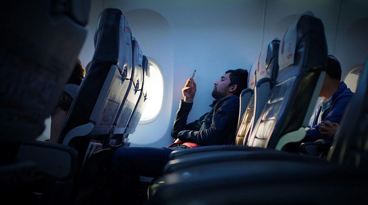 Stiff neck, long flights - don’t be this guy on your next trip. Grab a portable phone mount that keeps your phone out‑in‑front so you can stream, scroll, and relax without holding it the whole time