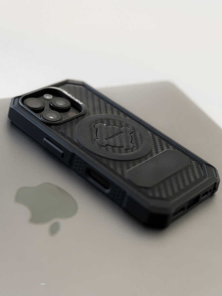 A close-up shot of a Rugged iPhone case resting on a MacBook.
