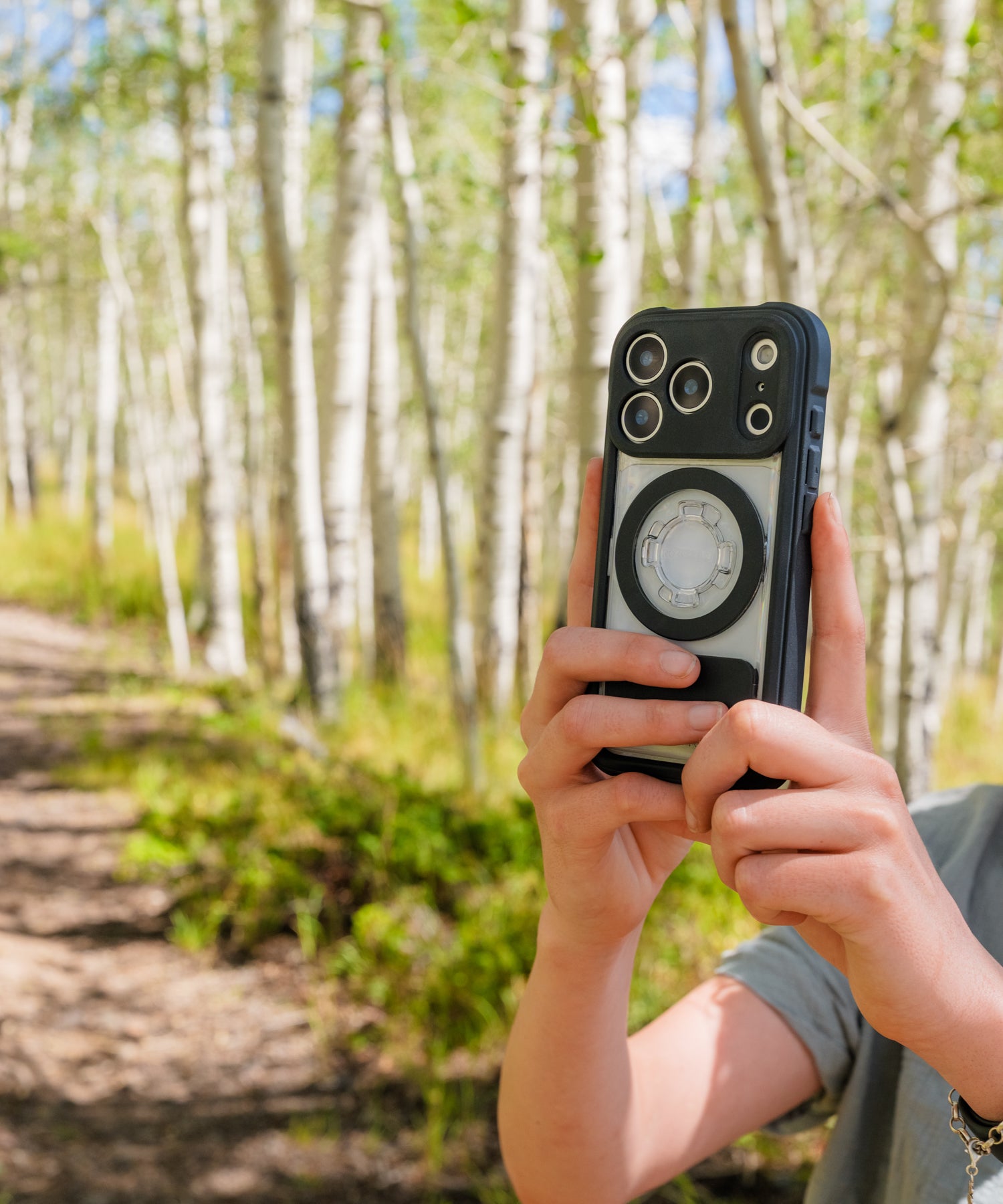 Woman photographing in the woods with an iPhone in a Rokform Crystal Case