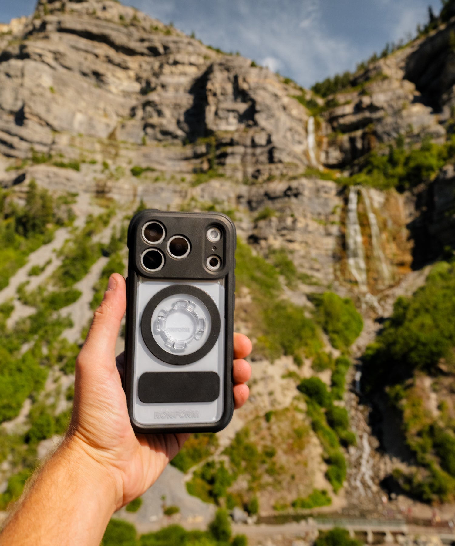 Rokform Crystal Case held in hand with a mountain range behind